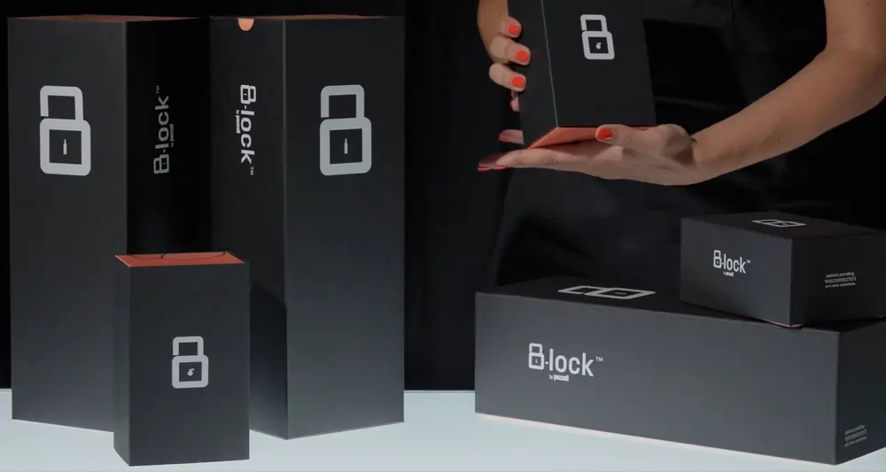 Le scatole B-lock nere col lucchetto bianco, una aperta fra le mani, una in piedi e una lunga per bottiglia