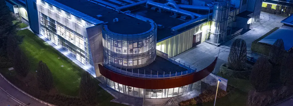 La sede di Pozzoli a Inzago al tramonto, con la fascia rossa sulla facciata e le vetrate accese