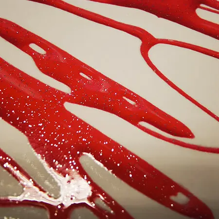 Gocce di vernice serigrafica rossa lucida su fondo chiaro