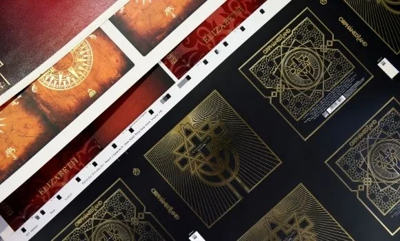 Fogli stampati in nero e oro, coi segni di registro sui margini