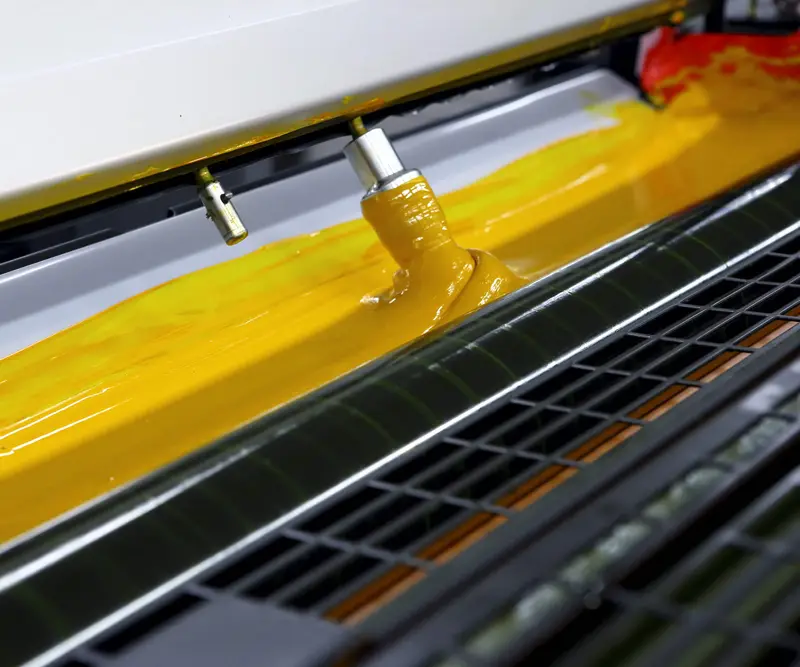 L'inchiostro giallo steso sui rulli di una macchina da stampa